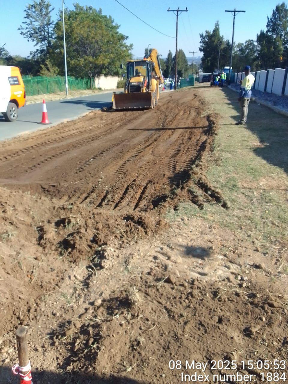 Backhoe loader shaping road layerworks at Waterfall Manor