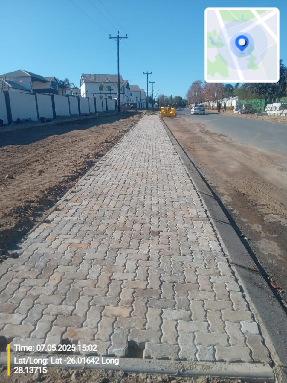 Completed interlocking block paved walkway alongside the road