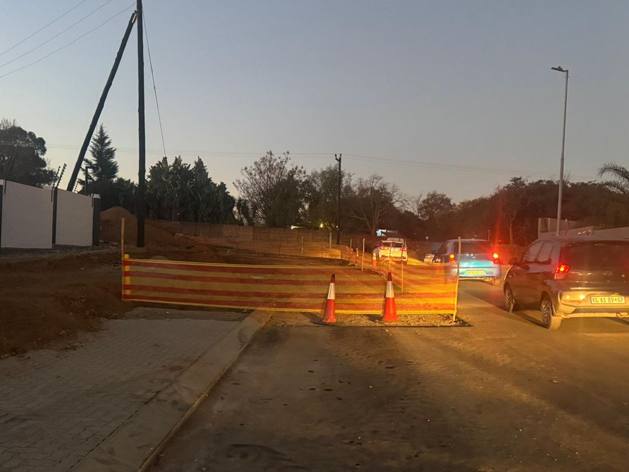 Traffic accommodation with cones and barrier netting at dusk on site